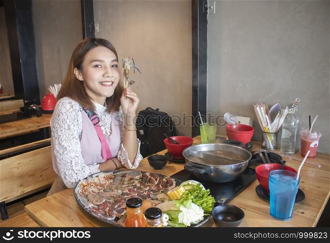 young asian woman enjoy eating Shabu-Shabu japanese hot pot