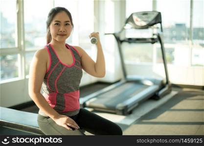 Young asian woman exercising with dumbbells
