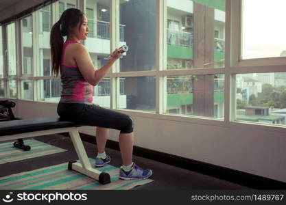 Young asian woman exercising with dumbbells