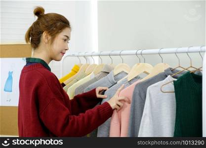 Young asian woman fashion designer working in studio with happiness emotion, small business owner, fashion industry concept