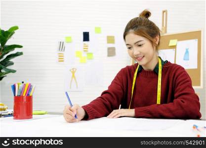 Young asian woman fashion designer working in studio with happiness emotion, small business owner, fashion industry concept