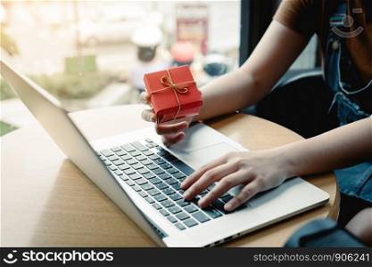 Young asian woman hand holding red gift box with shopping online concept.