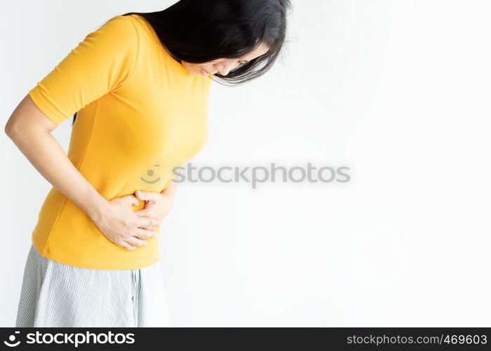 Young asian woman having painful stomachache on white background.Chronic gastritis. Abdomen bloating concept.