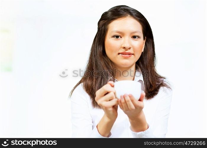 Young asian woman in casual. Image of young asian woman in casual wear holding a cup