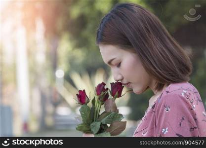 Young asian woman kissing a rose