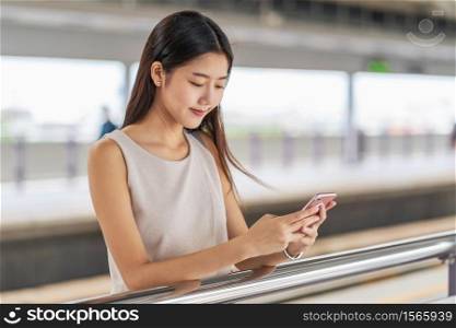 Young Asian woman passenger using social network via smart mobile phone in subway train when traveling in big city,japanese,chinese,Korean lifestyle and daily life, commuter and transportation concept