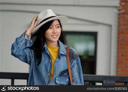 Young asian woman portrait smiling with happiness at city outdoors background, casual lifesyle, travel blogger