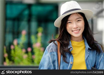 Young asian woman portrait smiling with happiness at city outdoors background, casual lifesyle, travel blogger