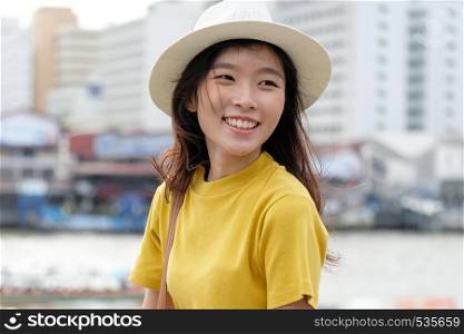 Young asian woman portrait smiling with happiness at city outdoors background, happy moment, casual lifesyle, travel blogger