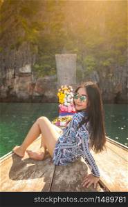 Young asian woman relax on long tail boat at Maya bay, Phi Phi island , Phuket in Thailand