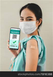 Young Asian woman shows vaccine passport on mobile phone to validate travel permission by the digital document. Young Asian woman shows vaccine passport on mobile phone
