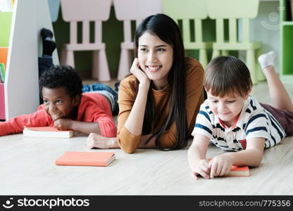 Young asian woman teacher and American, African boys in kindergarten classroom, preschool education concept