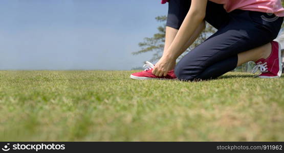 young asian woman tying shoelace