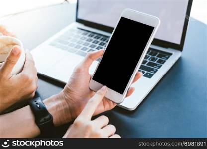 Young Asian woman using smartphone mock up blank black screen in cafe. Lifestyle women communication and working in coffee shop concept.