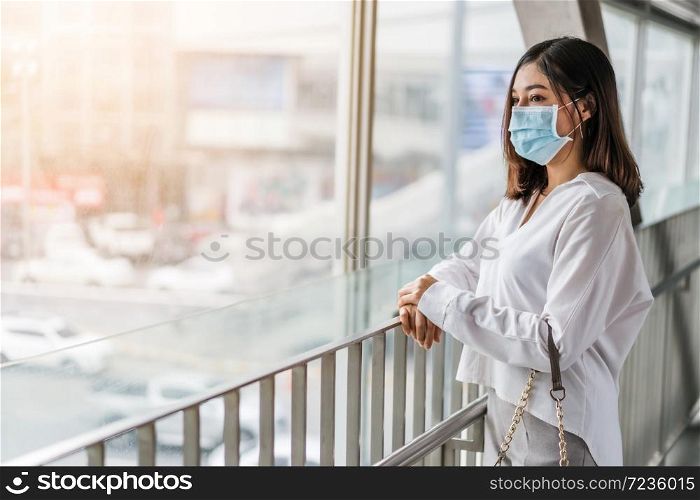 young asian woman wearing medical mask for prevention from coronavirus (Covid-19) pandemic in the city. new normal concepts