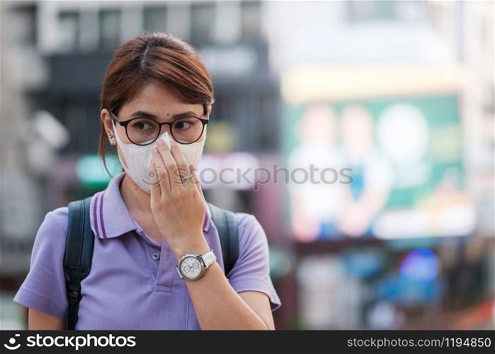 young Asian woman wearing protection mask against flu virus in the city. healthcare and air pollution concept