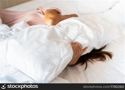 Young Asian woman with depression lie down alone on bed. Sad, unhappy, disappointed concept