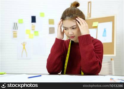 Young asian woman with frustrated expression while working at fashion design studio desk, people emotional and office lifestyle
