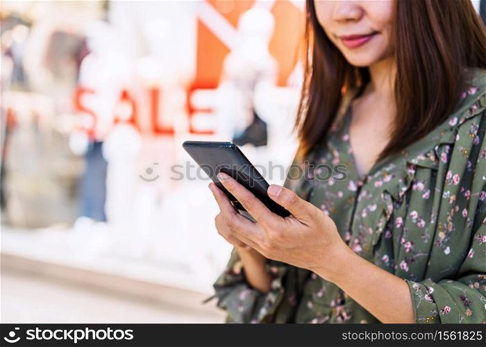 Young asian woman with shopping bags using smart phone and shopping at mall, Woman lifestyle concept