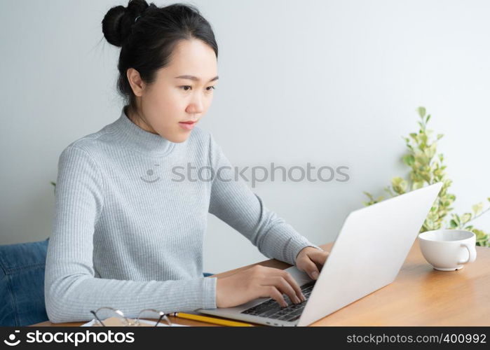 Young asian woman working on laptop in the home office desk.