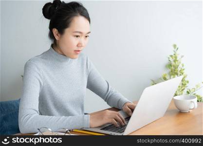 Young asian woman working on laptop in the home office desk.
