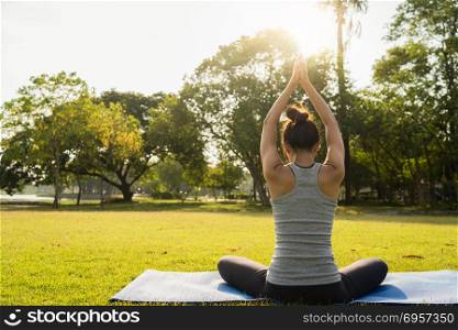 Young asian woman yoga outdoors keep calm and meditates while pr. Young asian woman yoga outdoors keep calm and meditates while practicing yoga to explore the inner peace. Yoga and meditation have good benefits for health. Yoga Sport and Healthy lifestyle concept.