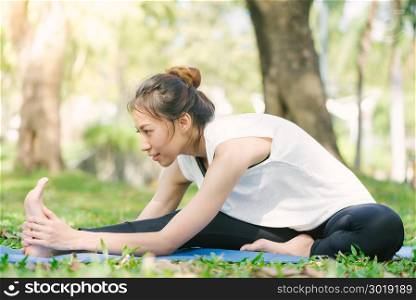 Young asian woman yoga outdoors keep calm and meditates while practicing yoga to explore the inner peace. Yoga and meditation have good benefits for health. Yoga Sport and Healthy lifestyle concept.