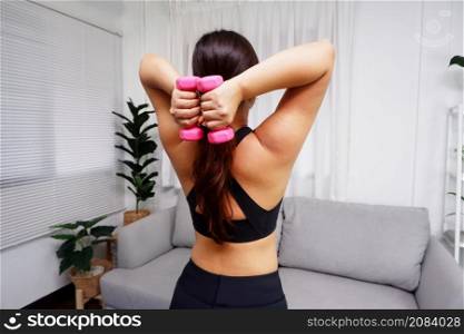 Young Asian women doing exercise at home using dumbbell for exercise arms and upper body