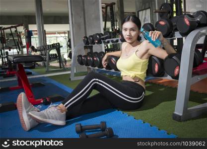 Young asian women sitting relaxing after training with Mineral drink