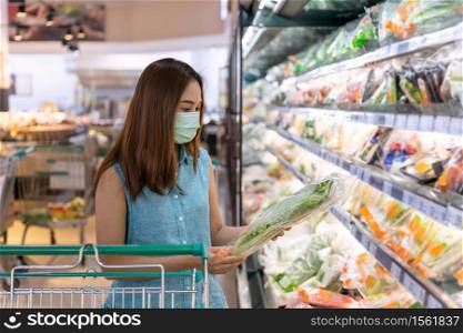 Young asian women wearing surgical mask buying fresh vegetable in grocery store at supermarket during coronavirus outbreak, New normal lifestyle concept