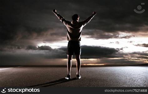Young athlete looking at the dark sky