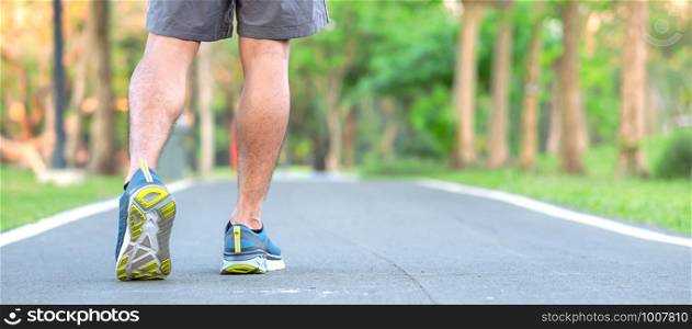 Young athlete man with running shoes in the park outdoor, male runner ready for jogging on the road outside, asian Fitness walking and exercise on footpath in morning. wellness and sport concepts