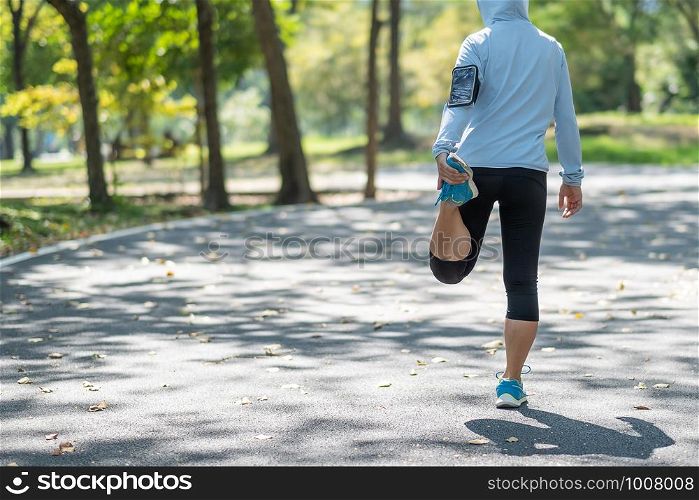 Young athlete woman streching in the park outdoor, female runner warm up ready for jogging on the road outside, asian Fitness walking and exercise on footpath in morning. wellness and sport concepts