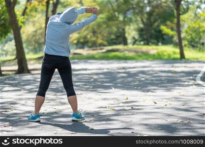 Young athlete woman streching in the park outdoor, female runner warm up ready for jogging on the road outside, asian Fitness walking and exercise on footpath in morning. wellness and sport concepts