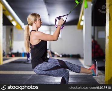 young athlete woman working out pull ups with gymnastic rings at the crossfitness gym. woman working out pull ups with gymnastic rings