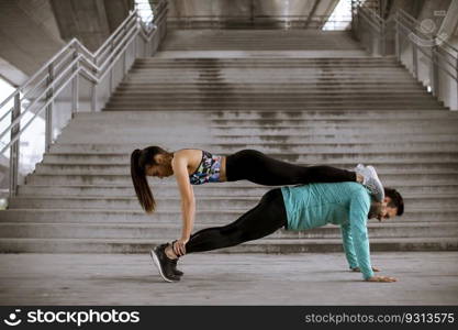 Young athletic couple doing push up outdoors