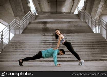 Young athletic couple doing push up outdoors