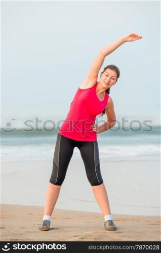 young athletic girl warming up near the sea