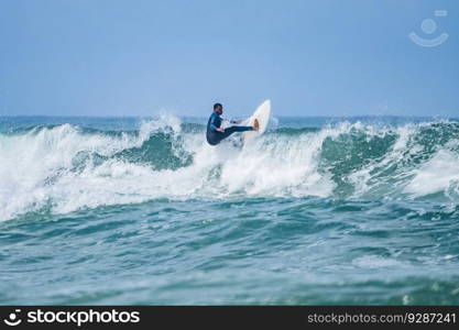 Young athletic surfer rides the wave in Furadouro Beach in Ovar, Portugal.