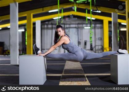 young athletic woman doing gymnastic exercise between two fit boxes at crossfitness gym. woman working out gymnastic exercise on fit boxes