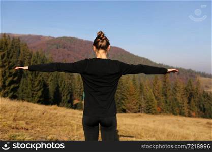 Young athletic woman stretching before intense morning workout at sunset or sunrise in beautiful mountain location. The concept of energy, health and harmony during sports.. Young athletic woman stretching before intense morning workout at sunset or sunrise in beautiful mountain location. The concept of energy, health and harmony during sports