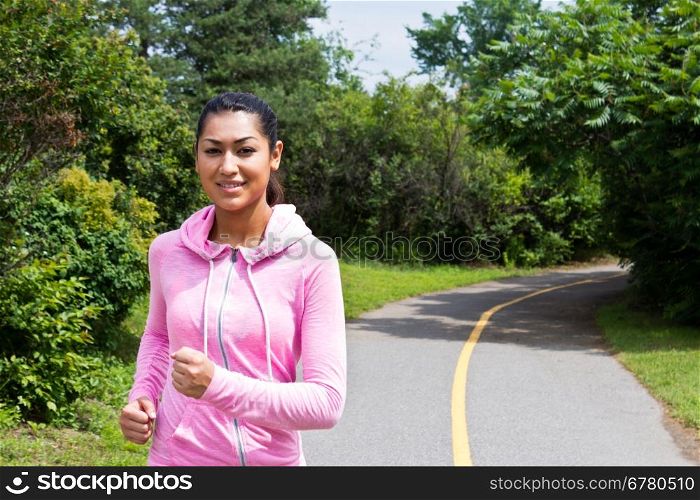 Young, atractive woman running on the nature trail