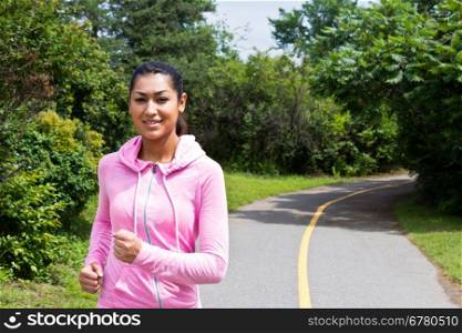 Young, atractive woman running on the nature trail