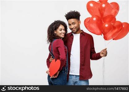 Young attactive African American couple holding heart balloon and paper. Young attactive African American couple holding heart balloon and paper.