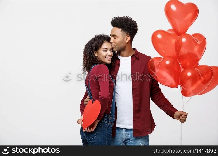 Young attactive African American couple holding heart balloon and paper. Young attactive African American couple holding heart balloon and paper.