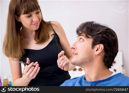 Young attracrive man visiting female barber 