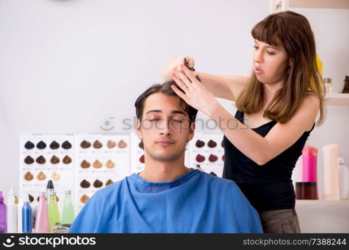 Young attracrive man visiting female barber 