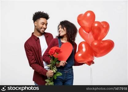 Young attractive african american couple on dating with red rose,heart and balloon. Young attractive african american couple on dating with red rose,heart and balloon.