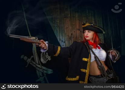 Young Attractive Armed Girl Pirate Captain Shoots Pistol Jolly Roger Flag Background. Girl Pirate Captain