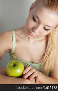 Young attractive blonde with green apple